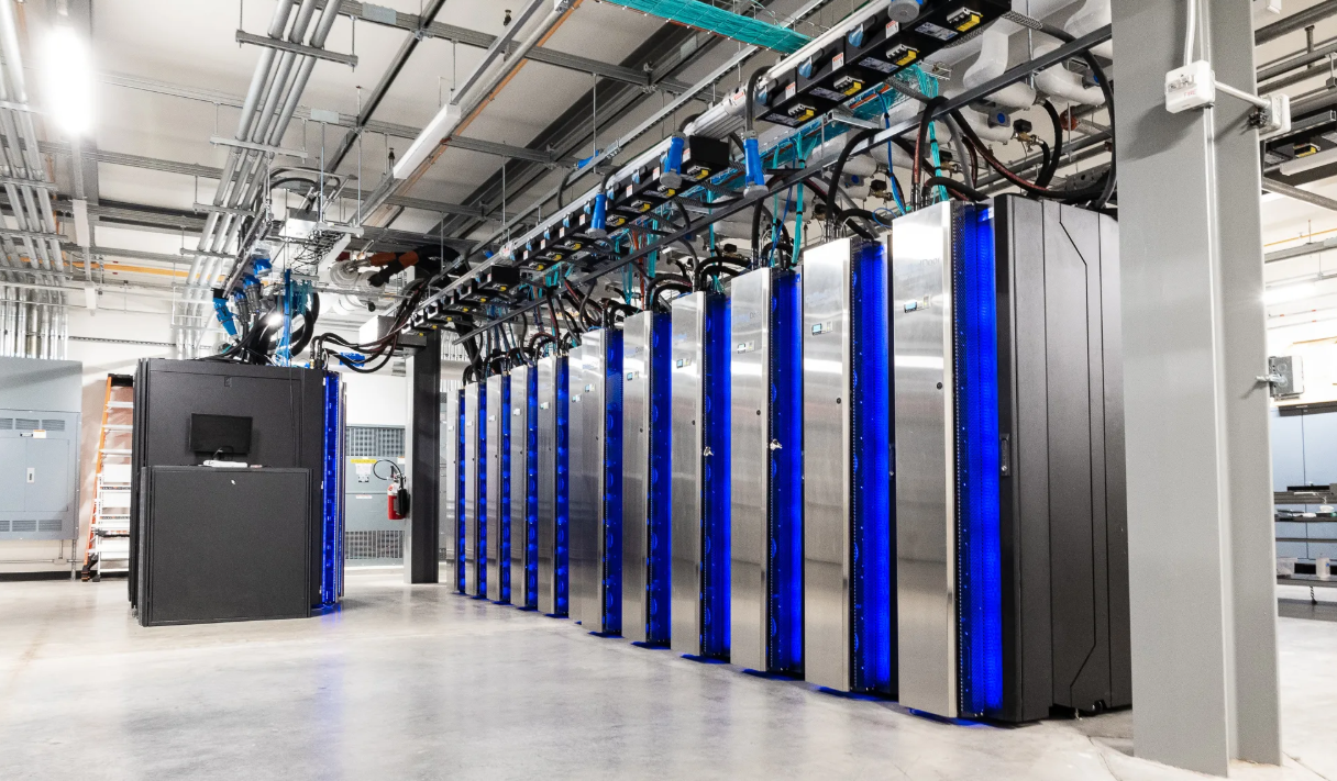A photo showing a bank of larger climate modeling supercomputers inside of a large industrial space.