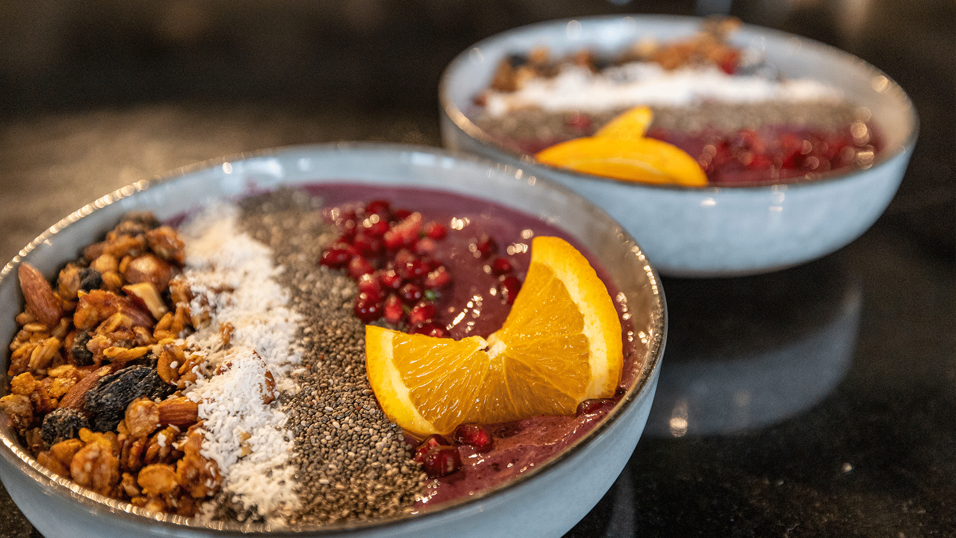 Close-Up von einer Acaii Bowl sehr schön angerichtet mit Nüssen, Granatapfelkernen und Orangenschnitz.