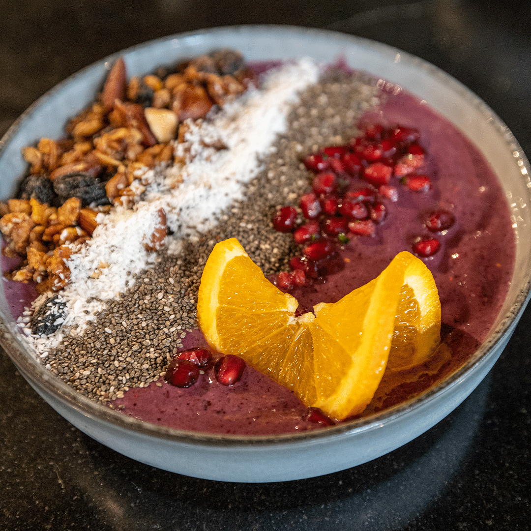 Close-Up von einer Acaii Bowl sehr schön angerichtet mit Nüssen, Granatapfelkernen und Orangenschnitz.