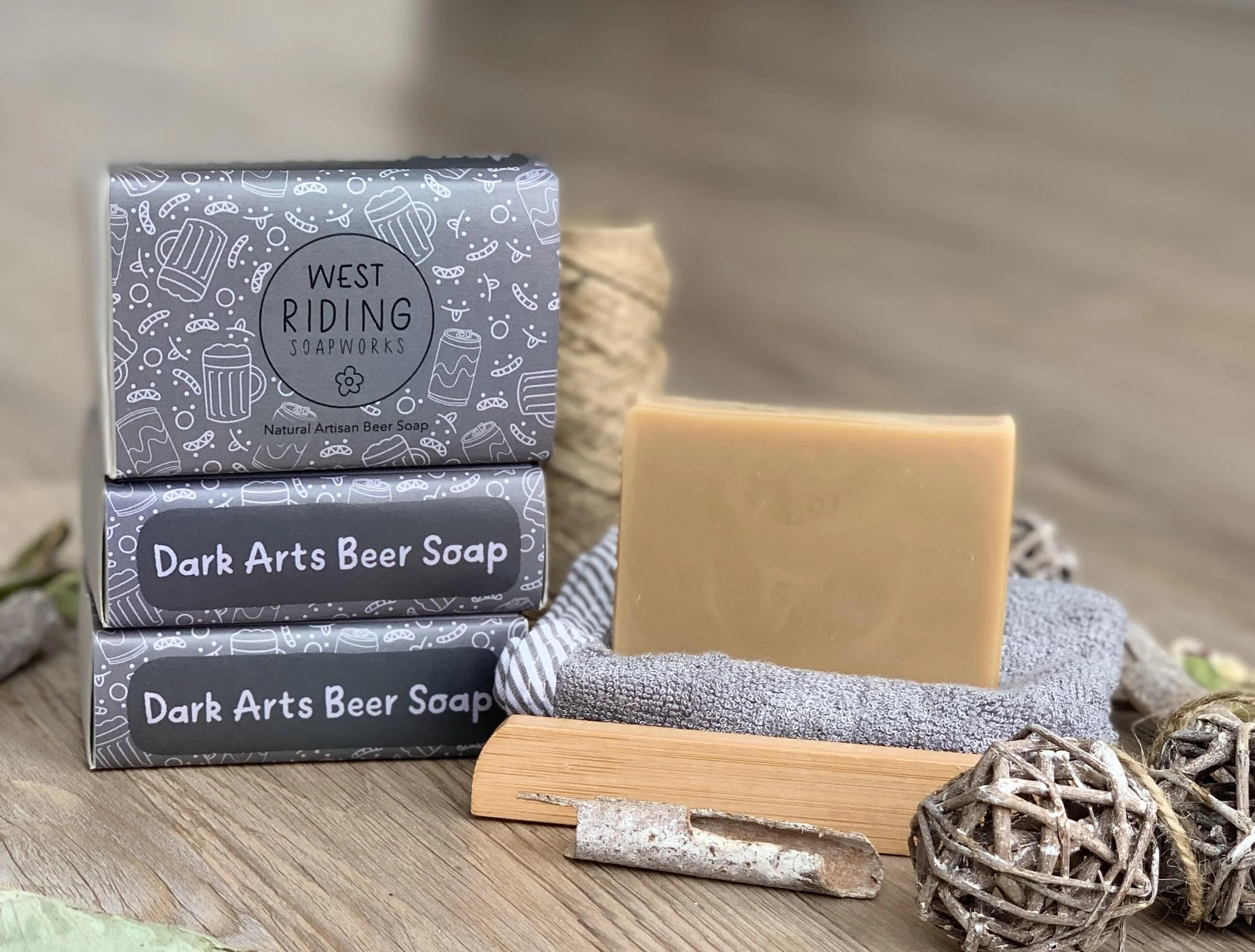 fudge-brown beer soap bar, next to it's uniquely designed packaging