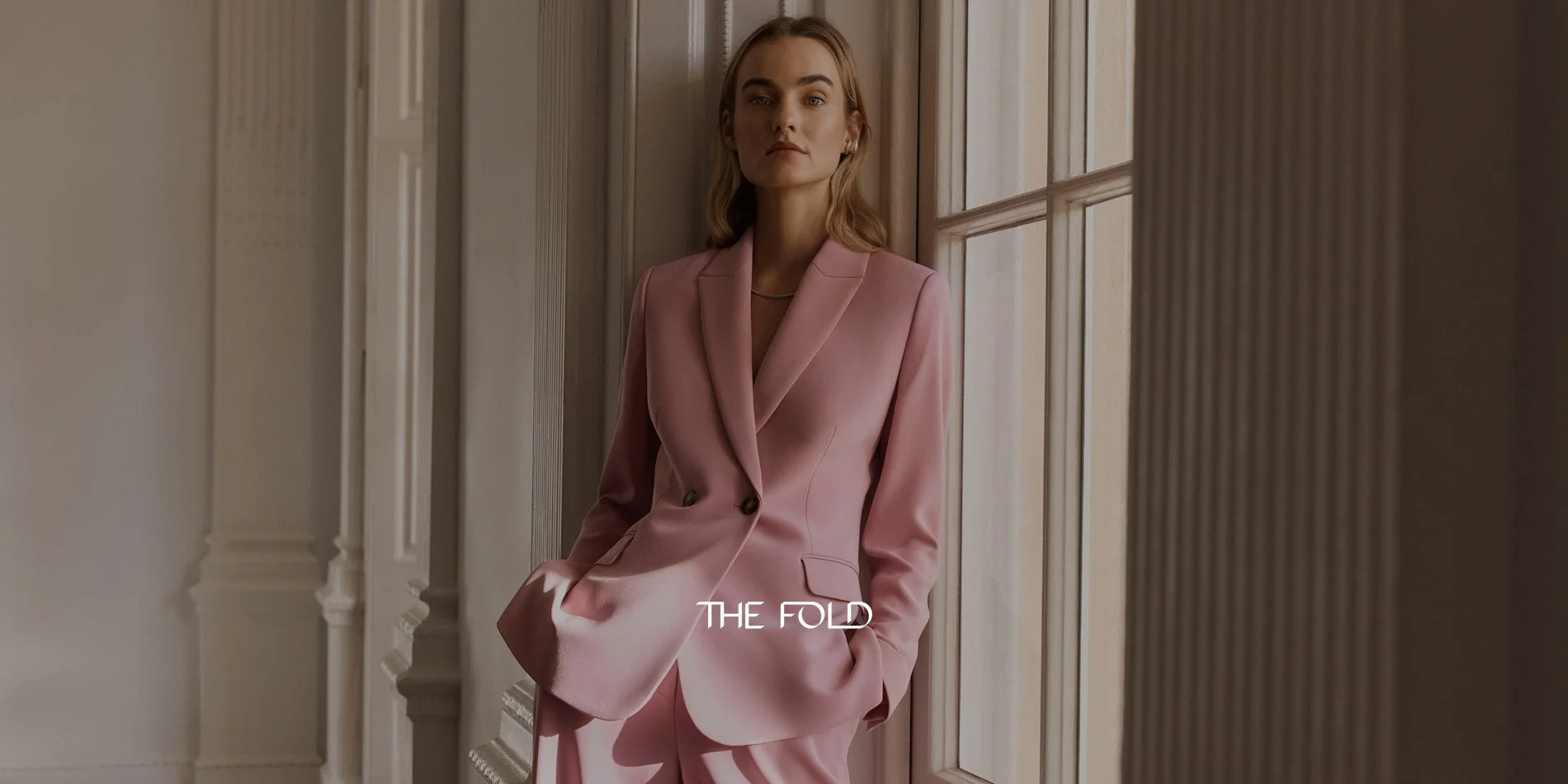 A woman wearing a baby pink suit