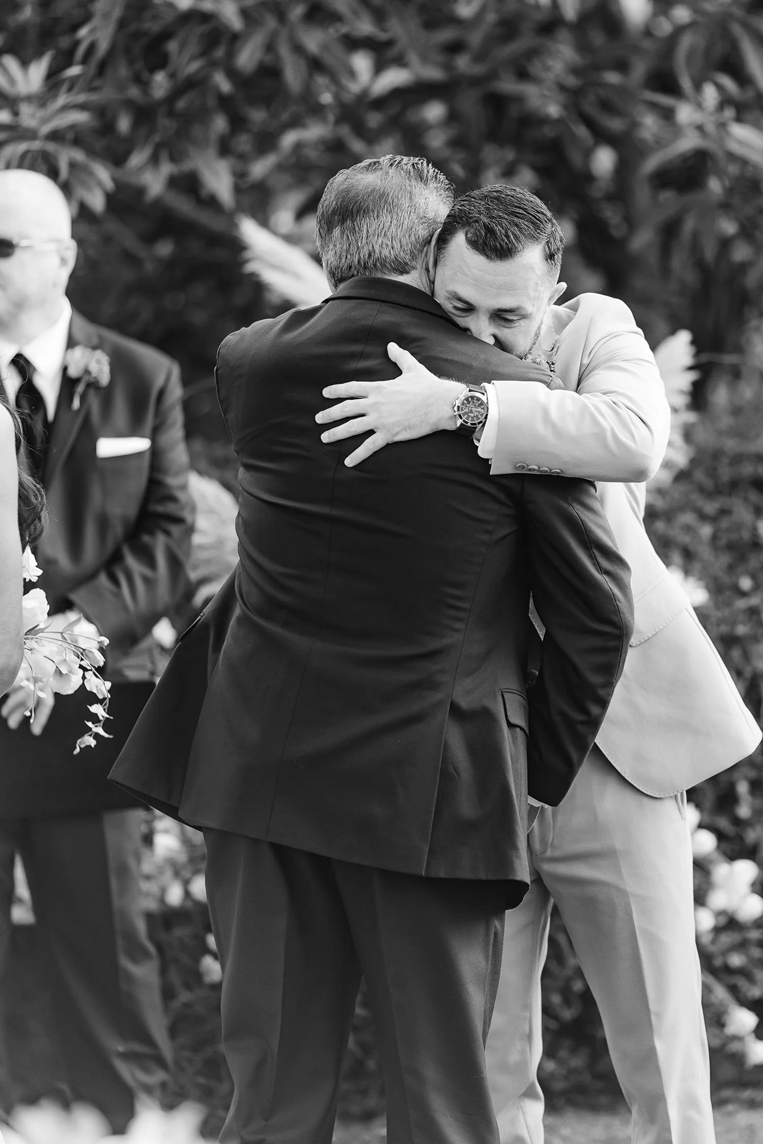 groom hugging the father of the bride down the aisle