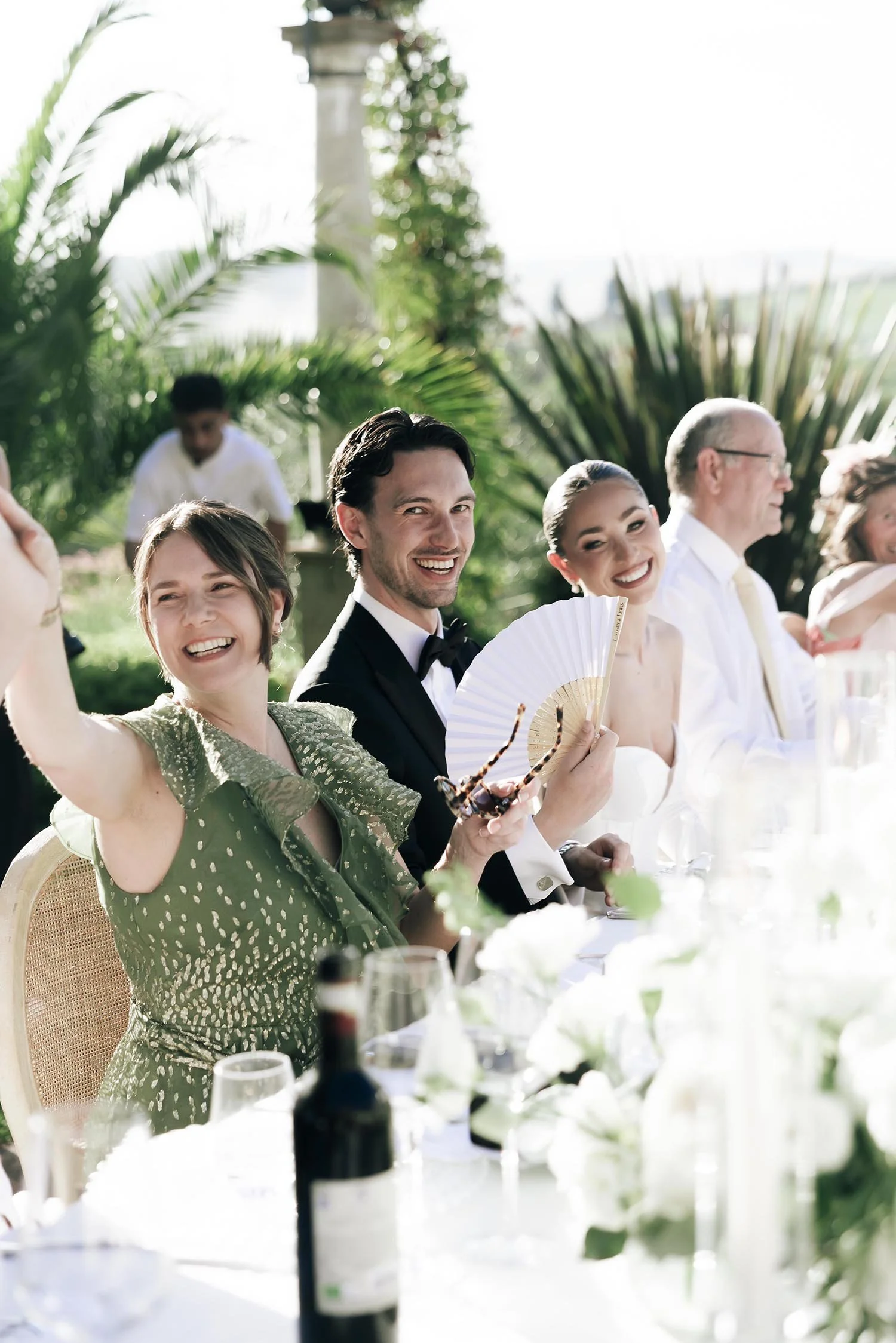 Bride and groom and their guests having fun during the speeches by the tables