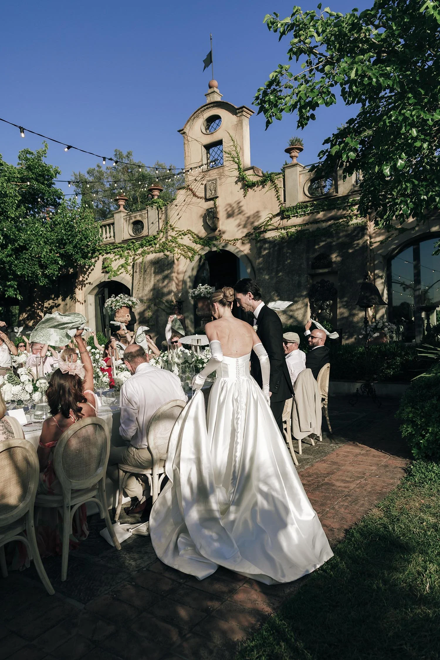 Bride and groom enter the dinner area and walk to the tables celebrated by their guests