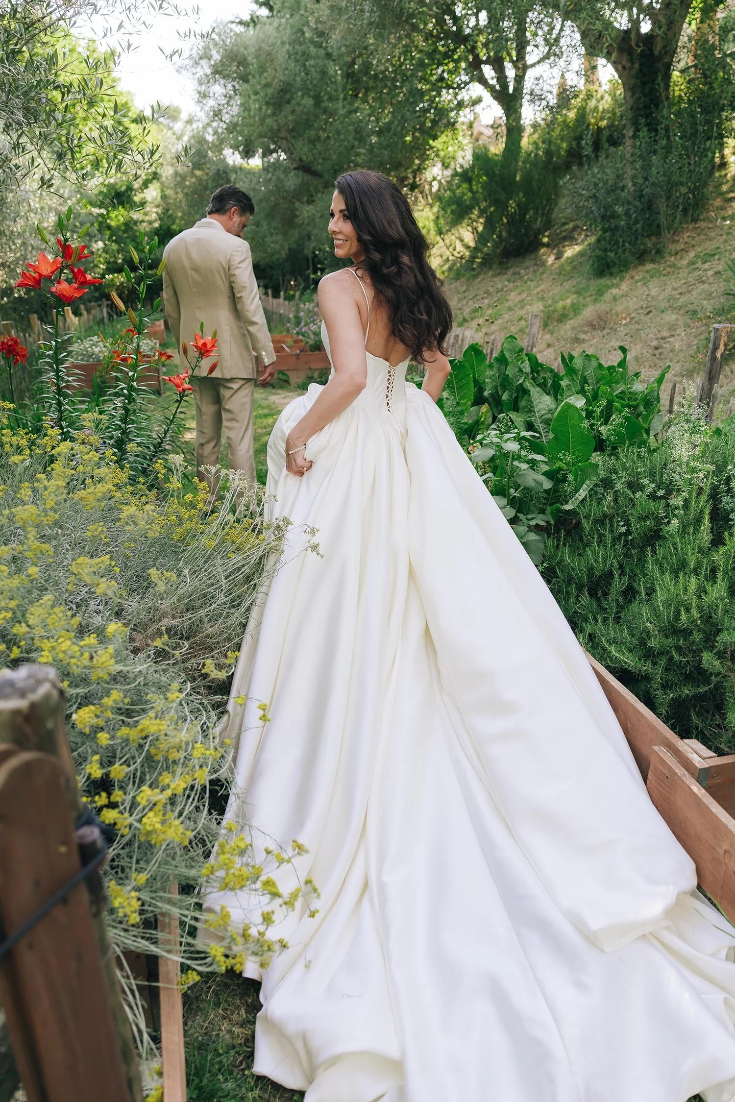bride and groom walk together in the garden