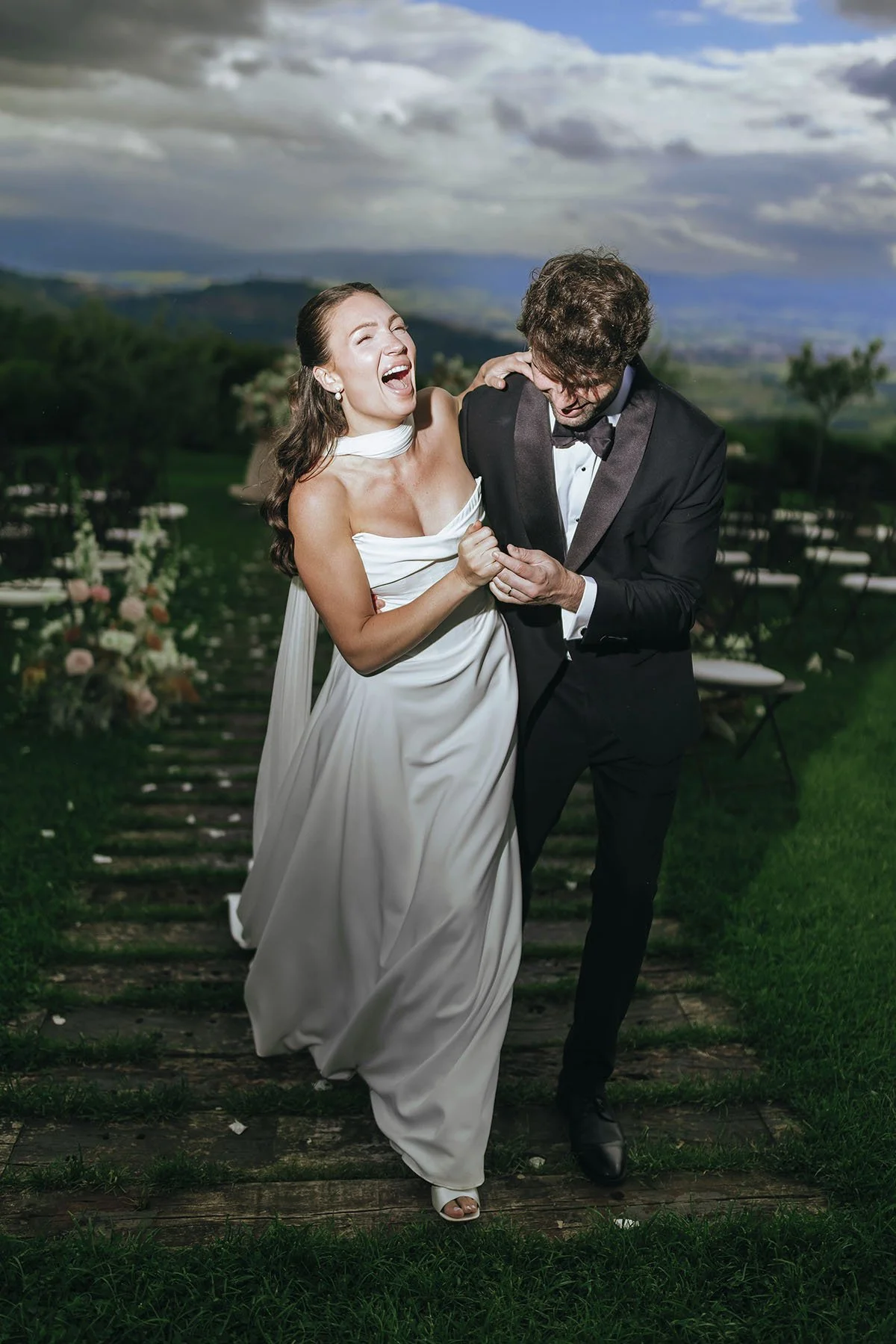 bride and groom walking together and holding each other in the gardens