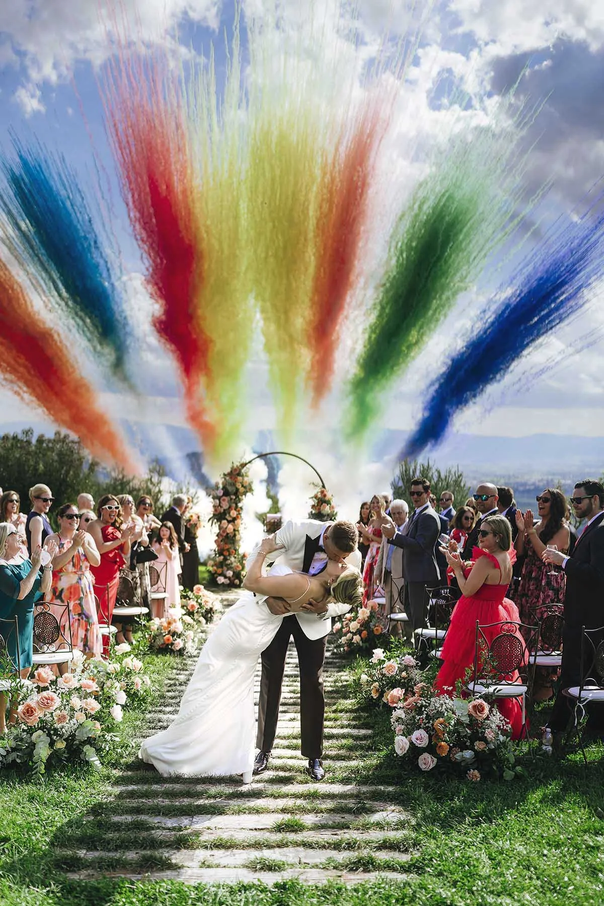 The first kiss of bride and groom after the wedding celebration at Castello di Petrata with colorful fireworks in the background