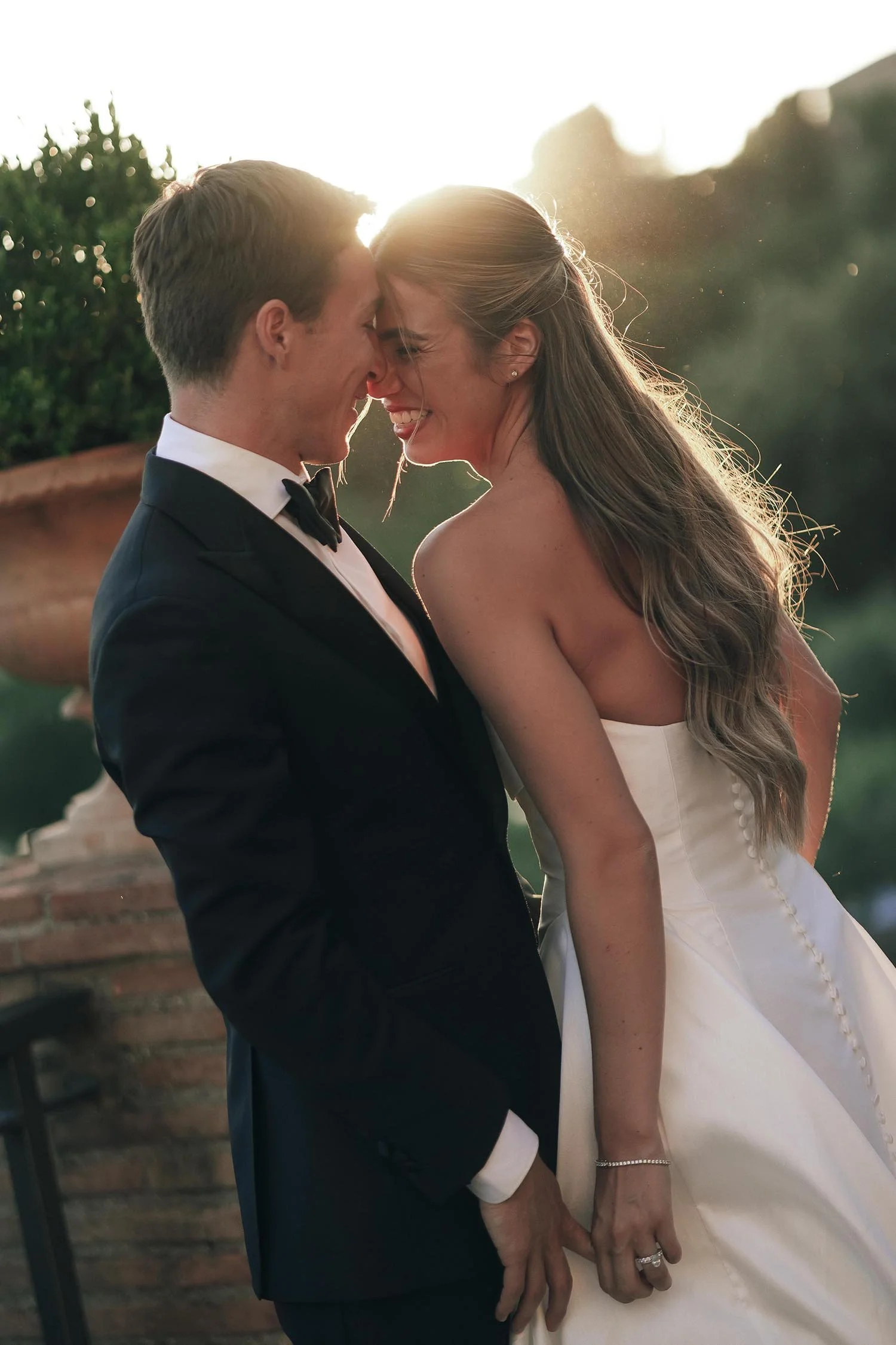 bride and groom candid laughing at each other and looking happy with the golden light of the sunset