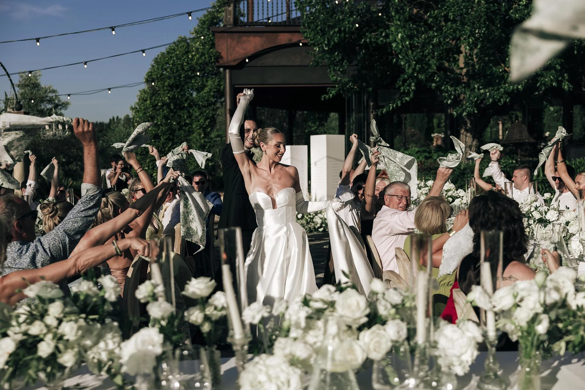Bride and groom enter the dinner area and walk to the tables celebrated by their guests