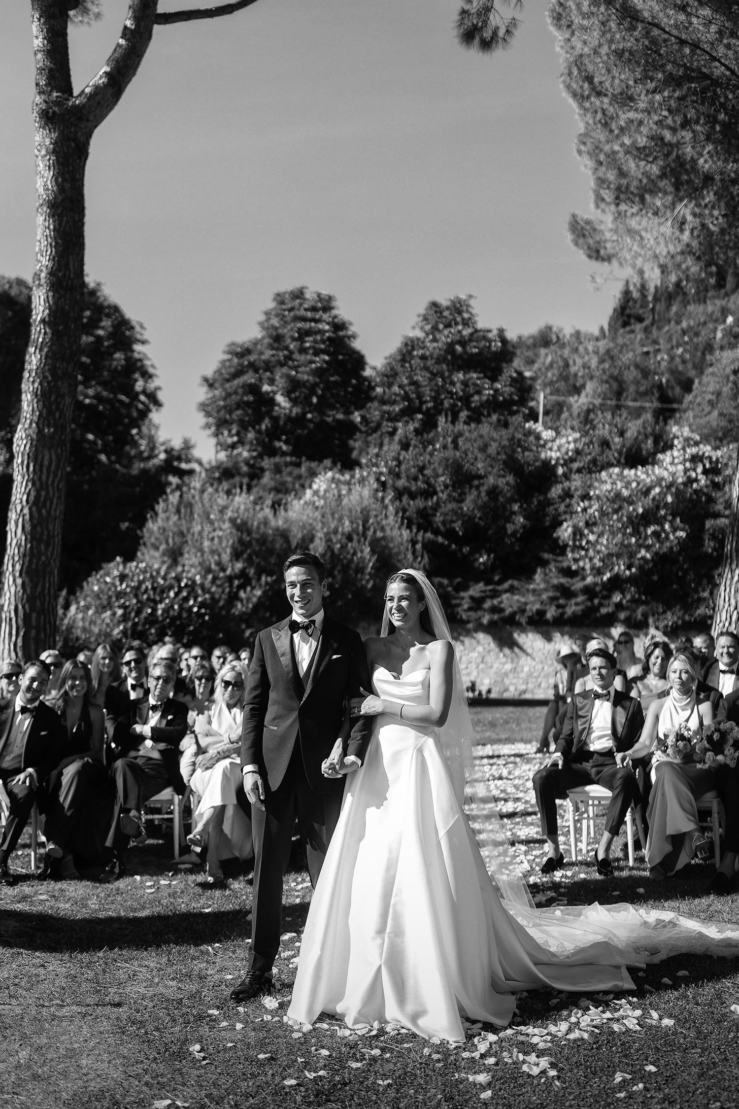 bride and groom holding each other during the ceremony with the guests sitting in the background