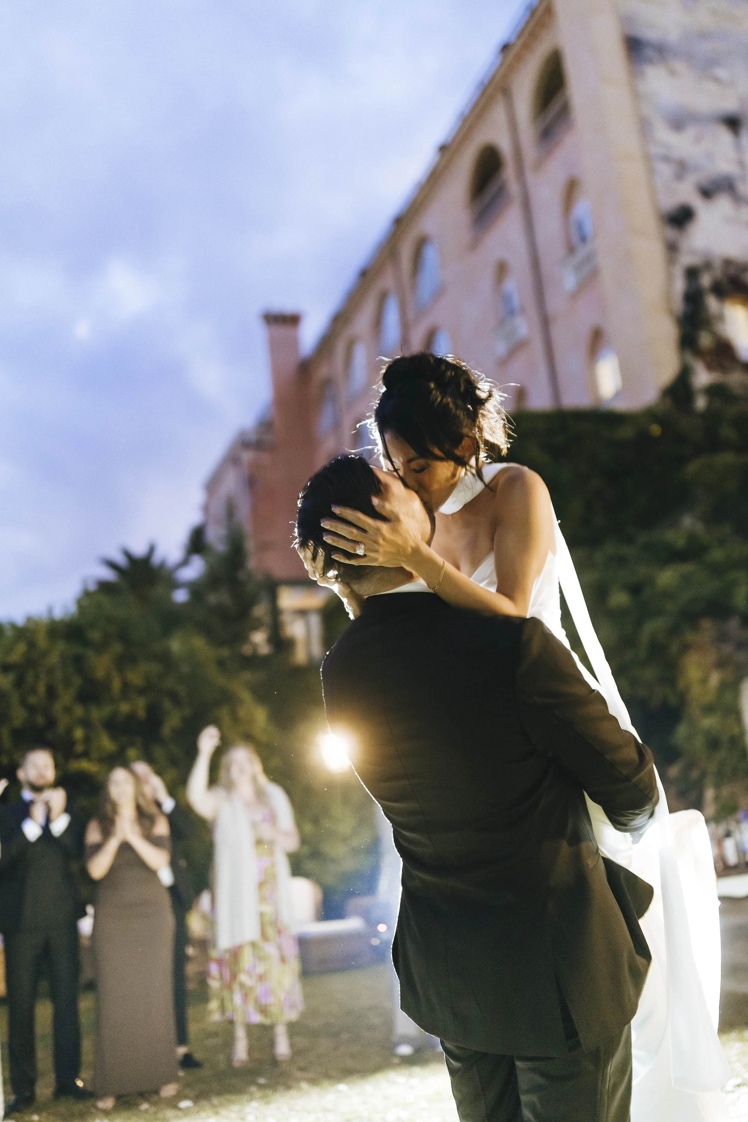 Timeless and fashion magazine style photo of bride and groom looking elegant and kissing during their first dance at Belmond Hotel Caruso in Ravello for their destination wedding in Ravello. Photo by Rellini art studio wedding photographer