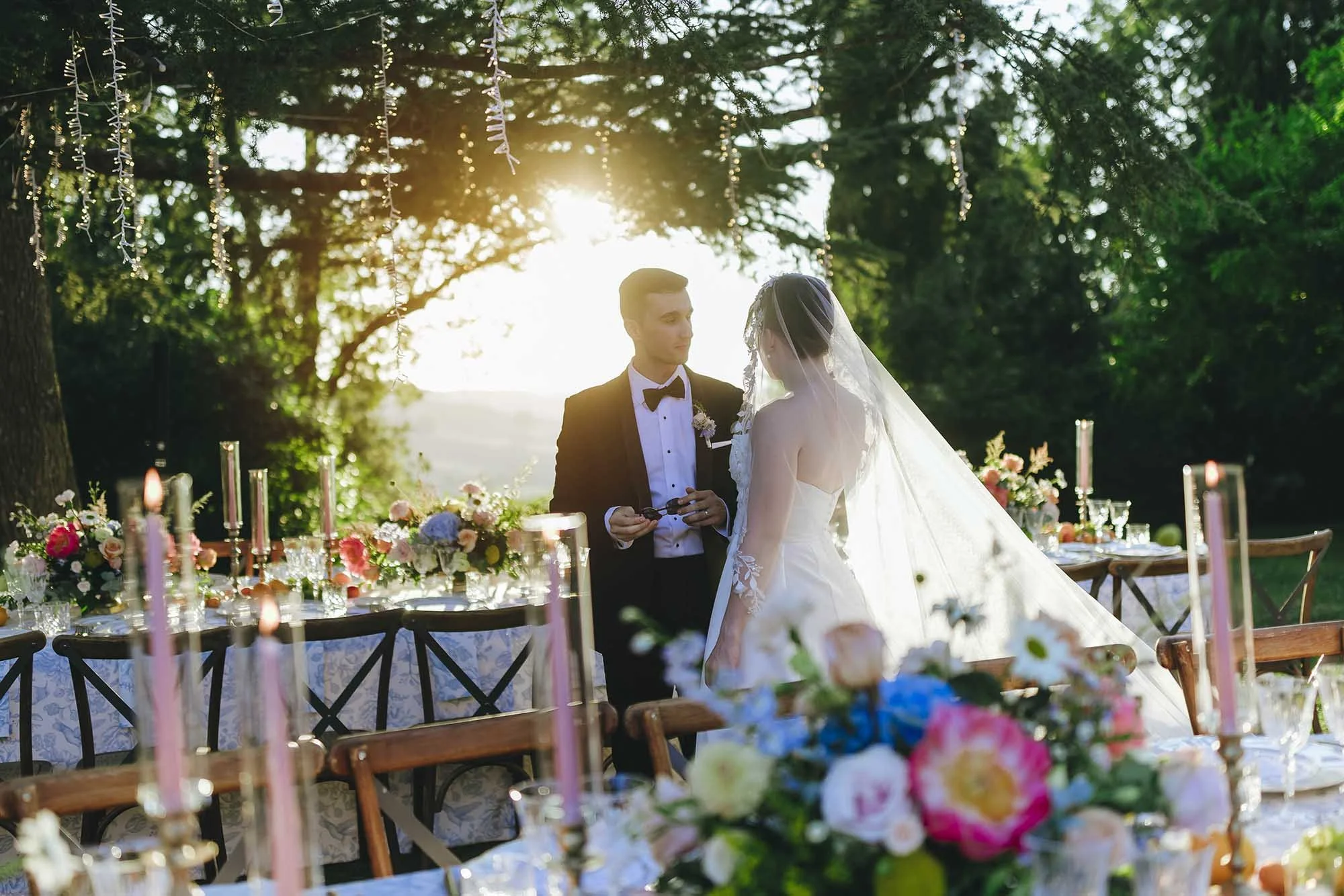 bride and groom together at sunset through the tables. photo by Rellini art studio best wedding photographer in Siena