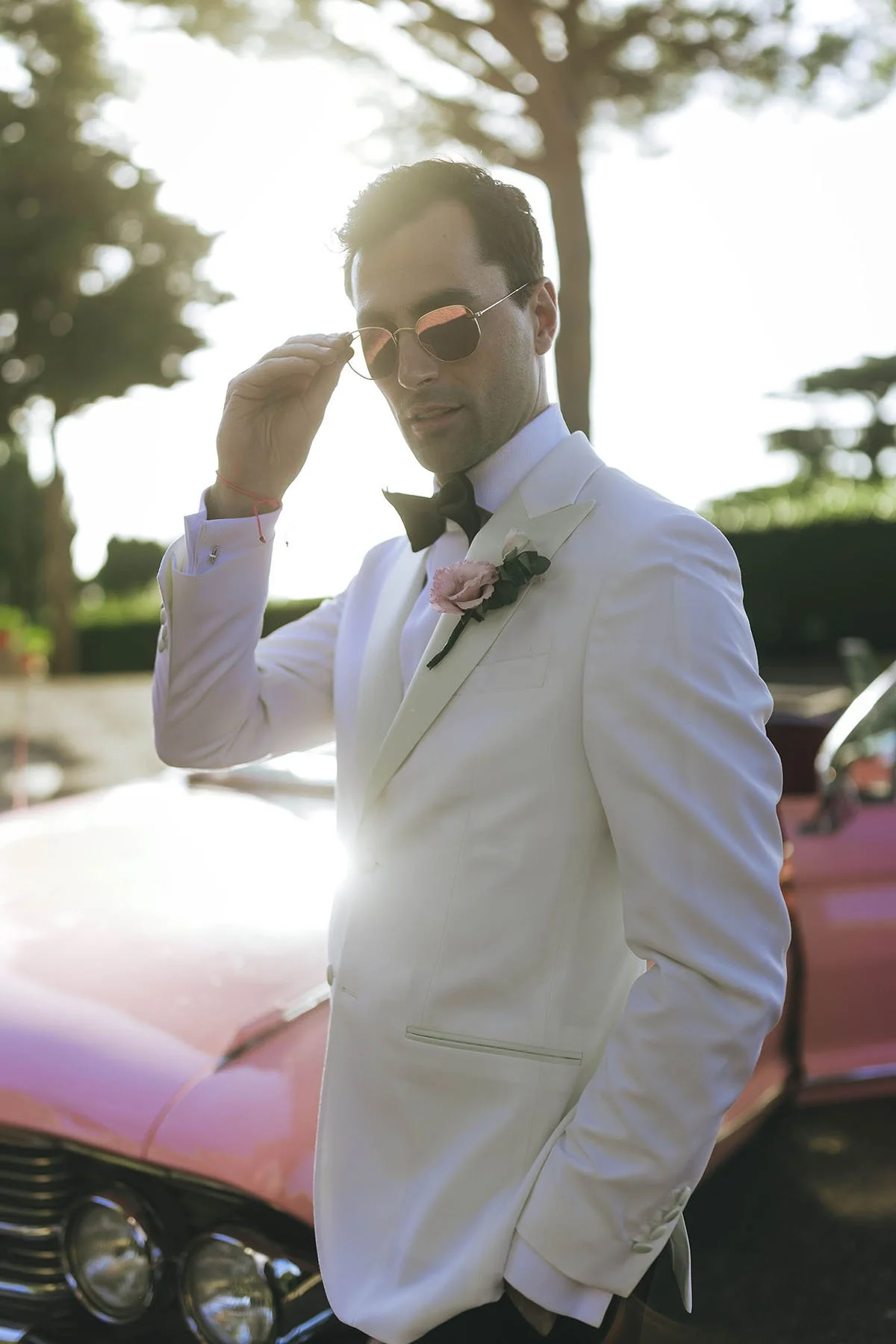 Classy portrait of the groom looking cool in his sunglasses with the sun setting behind the trees along the Amalfi Coast. photo by Rellini art studio, destination wedding photographers in Amalfi coast