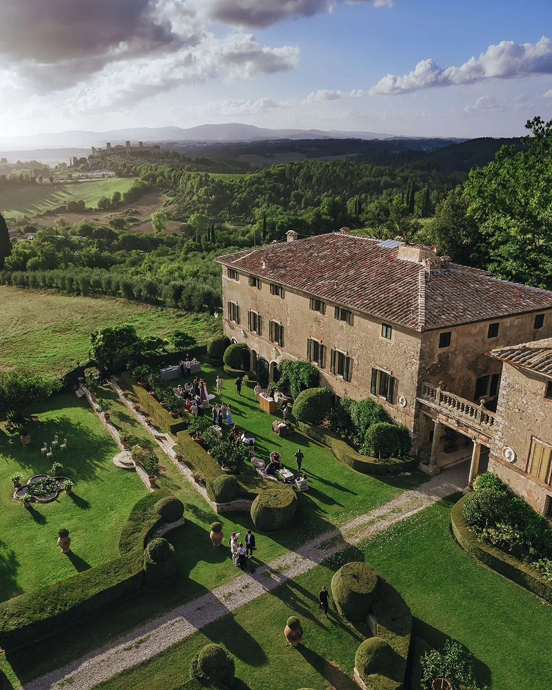 Aerial view of the cocktail reception with the sun setting on Borgo Stomennano and Monteriggioni in the background
