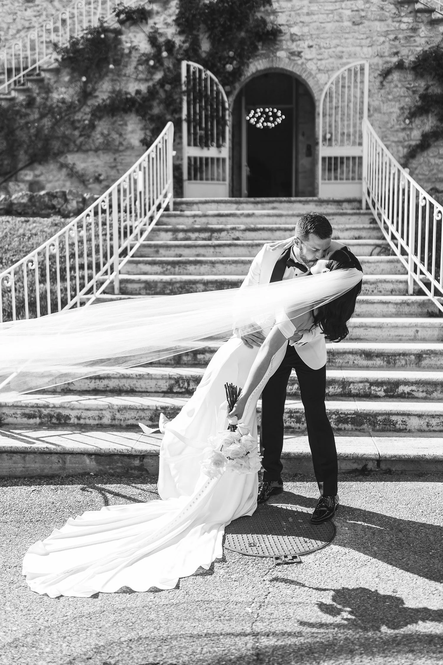 bride and groom kissing in the front of the castle facade