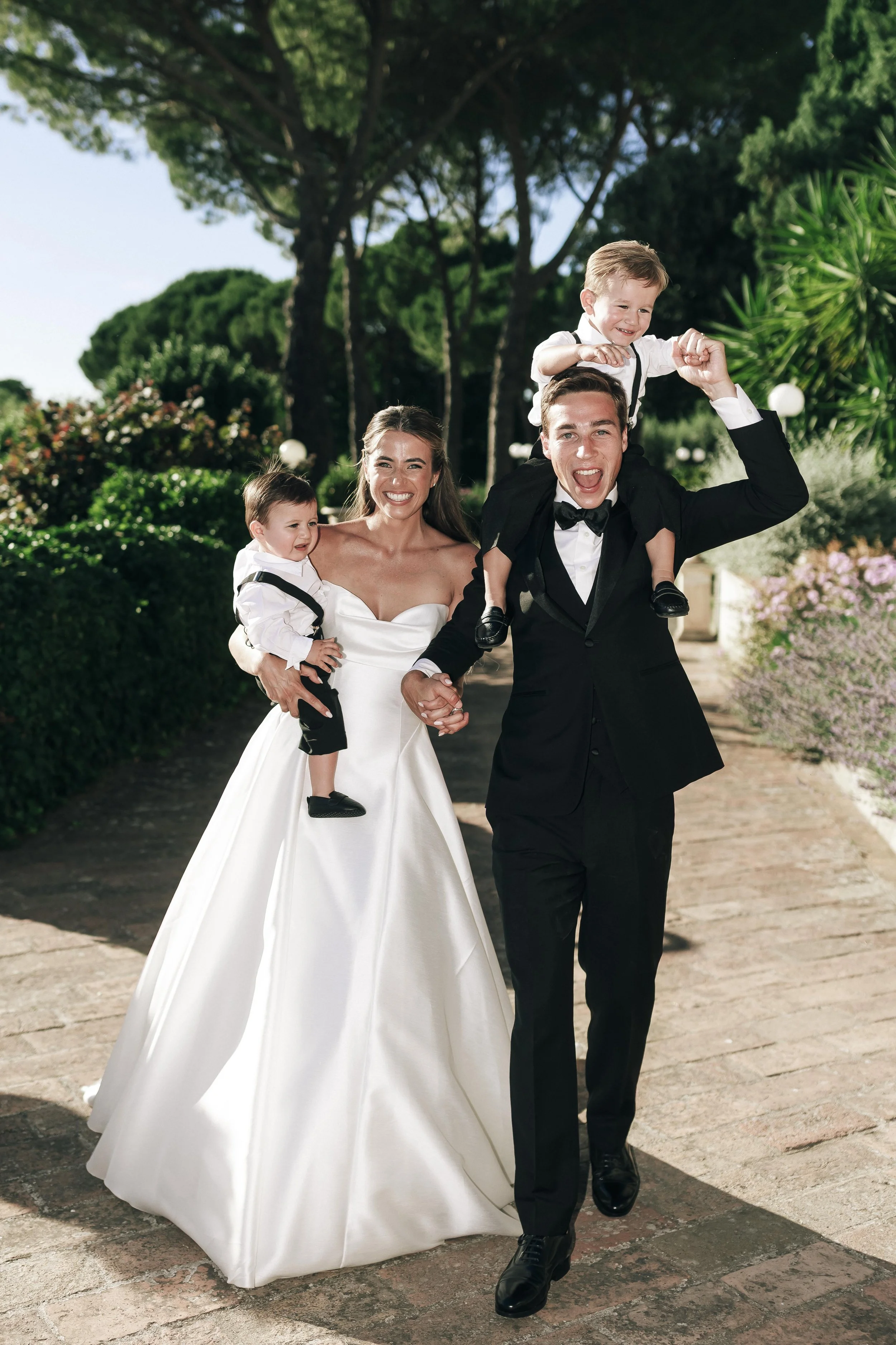 bride and groom holding their two sons and looking happy and smiling