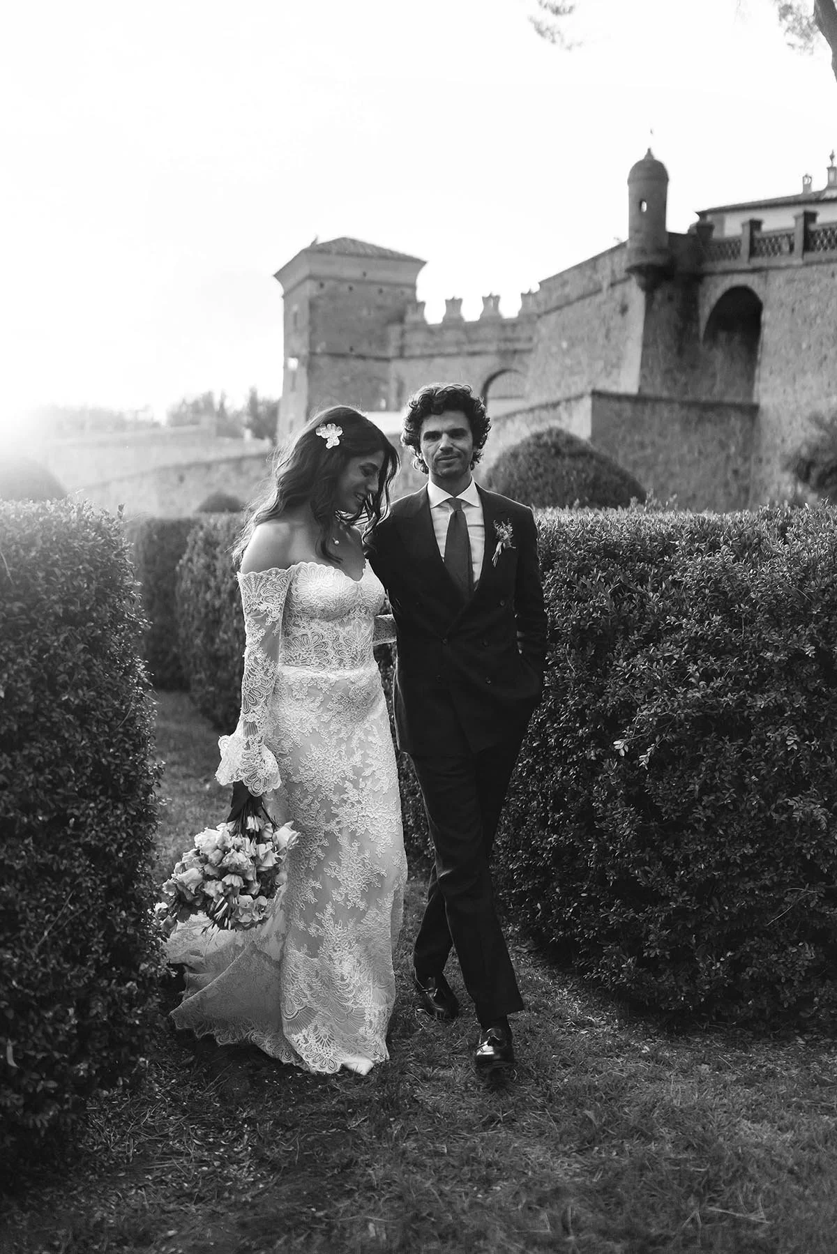 Bride and groom walking together in the garden after the ceremony with the castle in the background