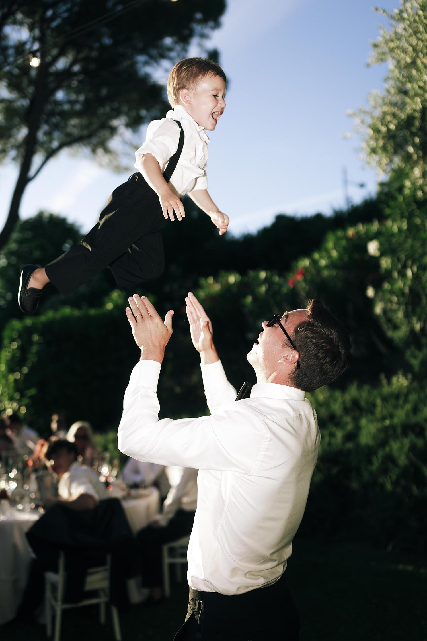 groom throwing his son in the air for fun