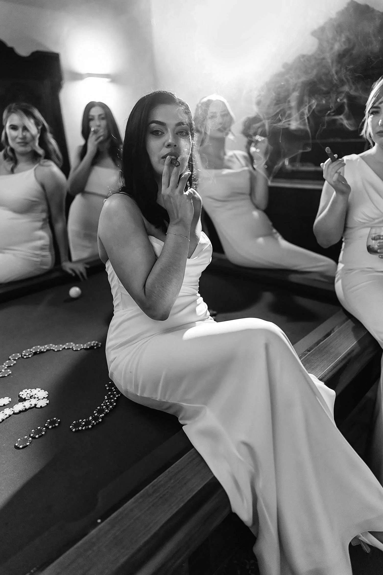Bride smoking with her bridesmaids looking elegant and sitting on a billiard in a room at Castello di Montignano in Umbria.  photo by Rellini art studio best wedding photographers in Italy
