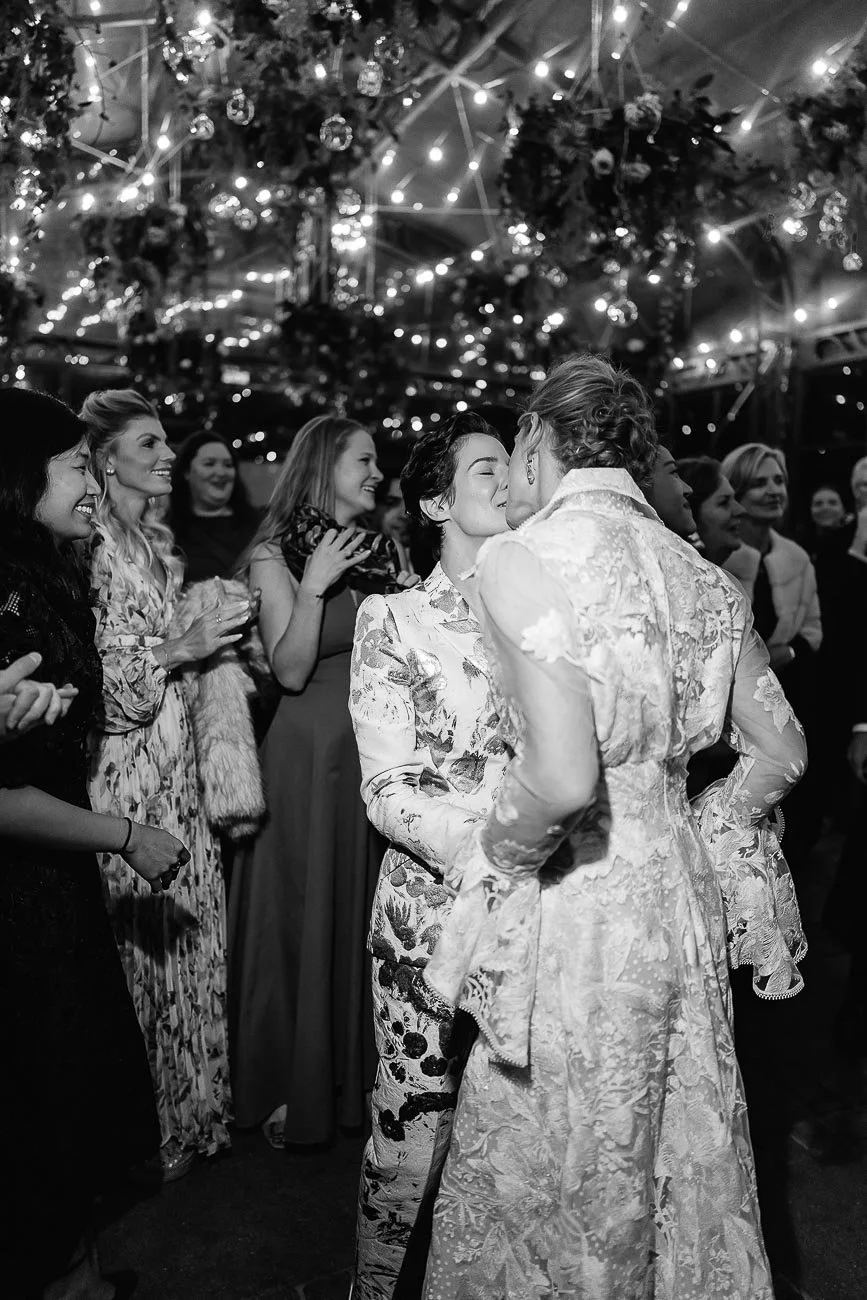two brides kiss each other during the party
