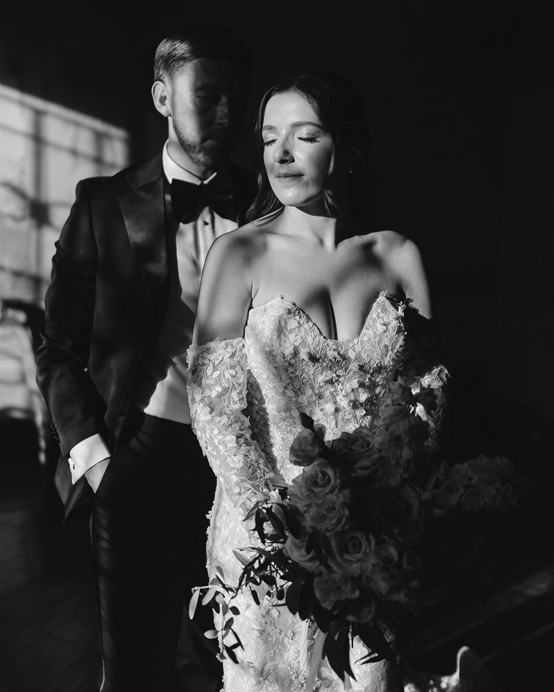 Bride and groom holding each other with eyes closed 