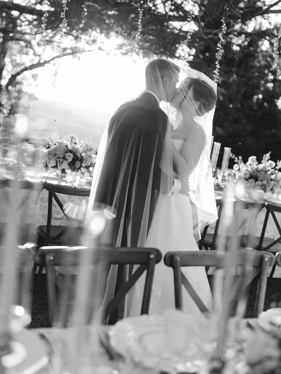 Bride and groom kiss under the veil at sunset at Borgo Laticastelli