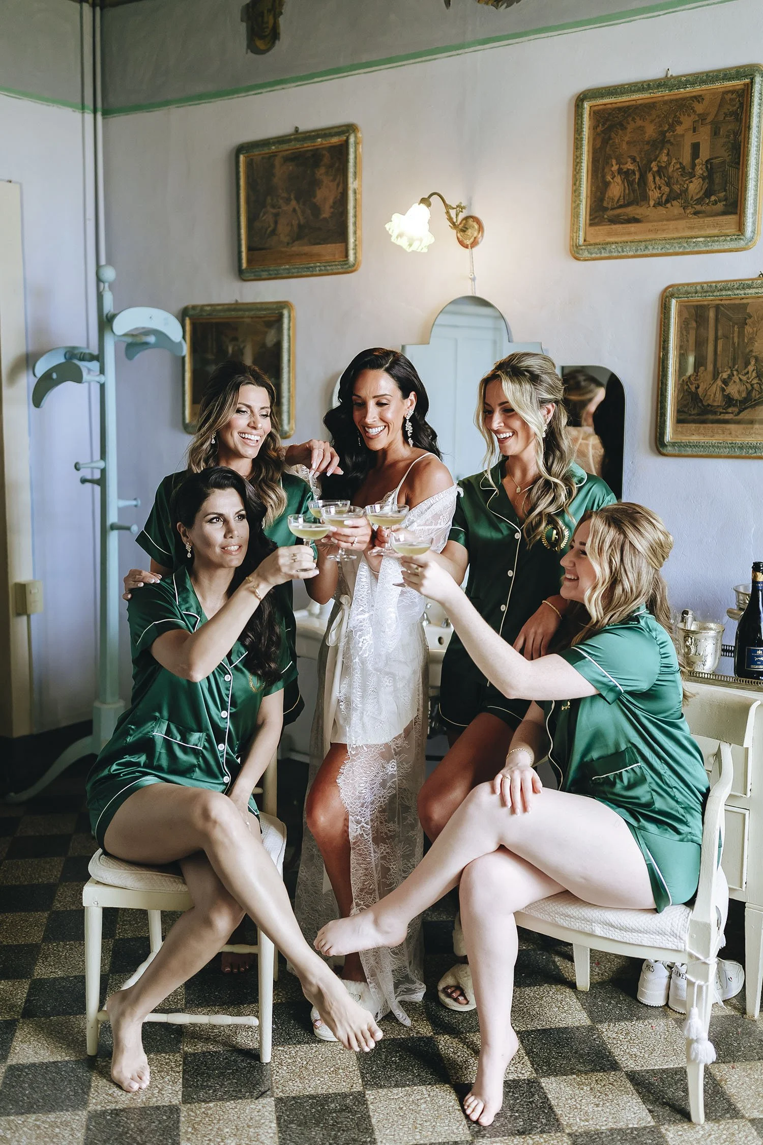 bride getting ready with her bridesmaids toasting with drinks in the restroom