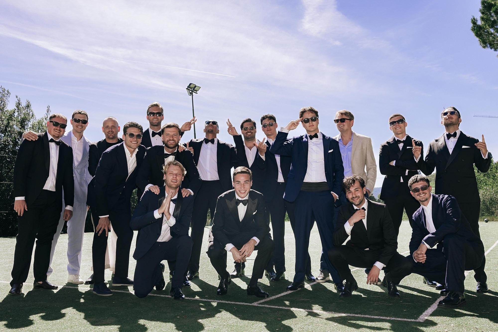 group photo of the groom and groomsmen on the tennis court