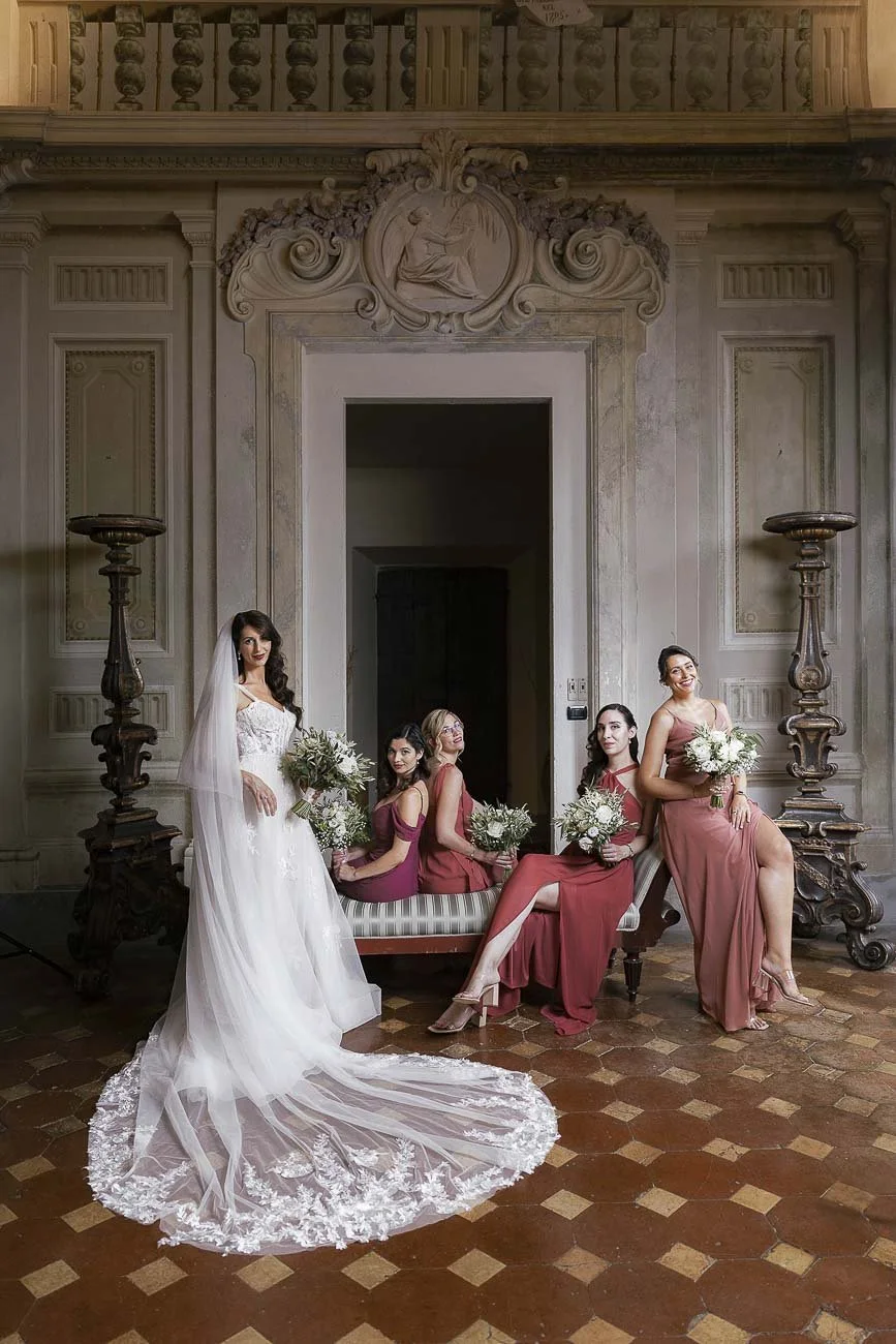 Destination wedding at Castello di Montegufoni in Florence, photo by Rellini art studio documentary wedding photographers in Tuscany. Editorial style group photo of the bride and bridesmaids in their dresses before walking down the aisle. 