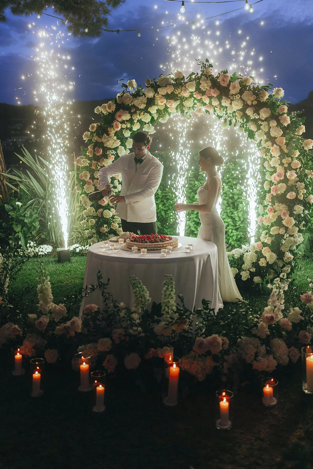 Bride and groom cutting the cake with fireworks at Villa Aura del Lago in Lake Como