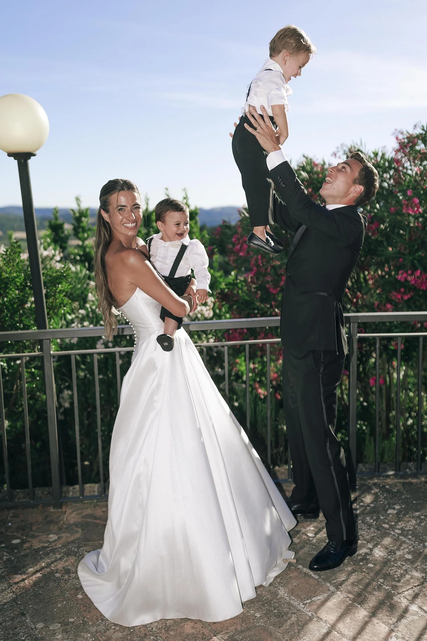 bride and groom holding their two sons and looking happy and smiling