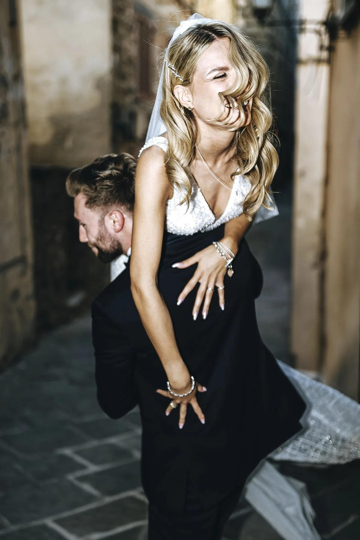 Groom lifting and holding the bride on the shoulder. They look happy having a great time. Photo by Rellini art studio best wedding photographer in Umbria