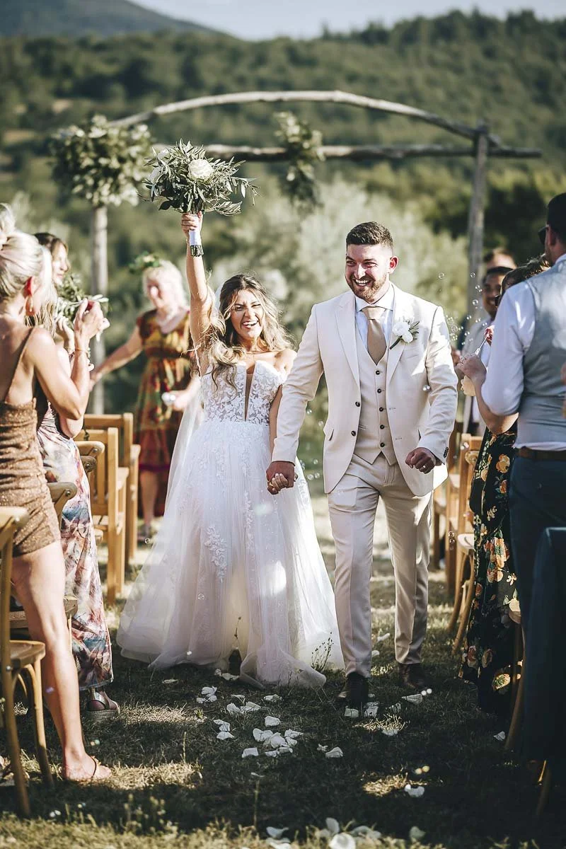 Destination wedding at Ristonchi castle near Florence in Tuscany.  the couple celebrated down the aisle with guests throwing confetti