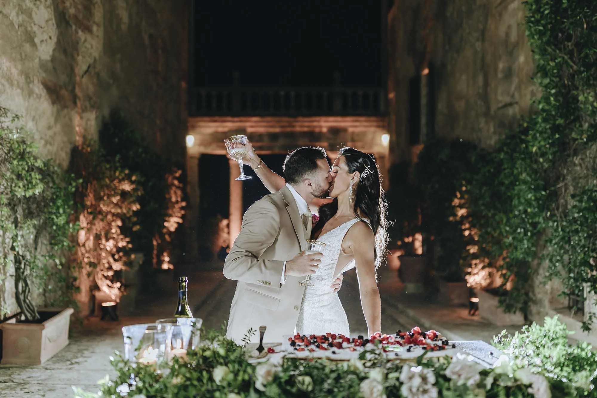 Bride and groom kiss after cutting the cake at Borgo Stomennano