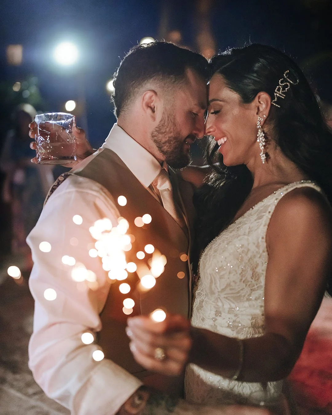 Bride and groom holding each other and holding sparklers