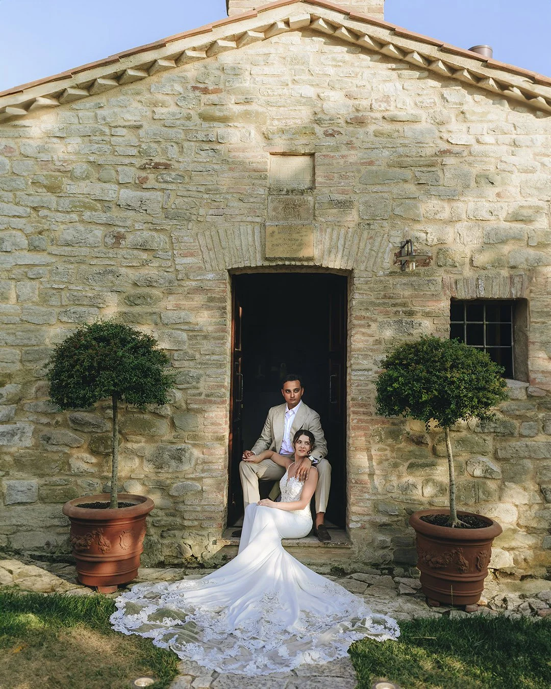 bride and groom sitting together and looking into the distance on the stairs of an old church at Borgo Castello Panicaglia wedding venue in Umbria