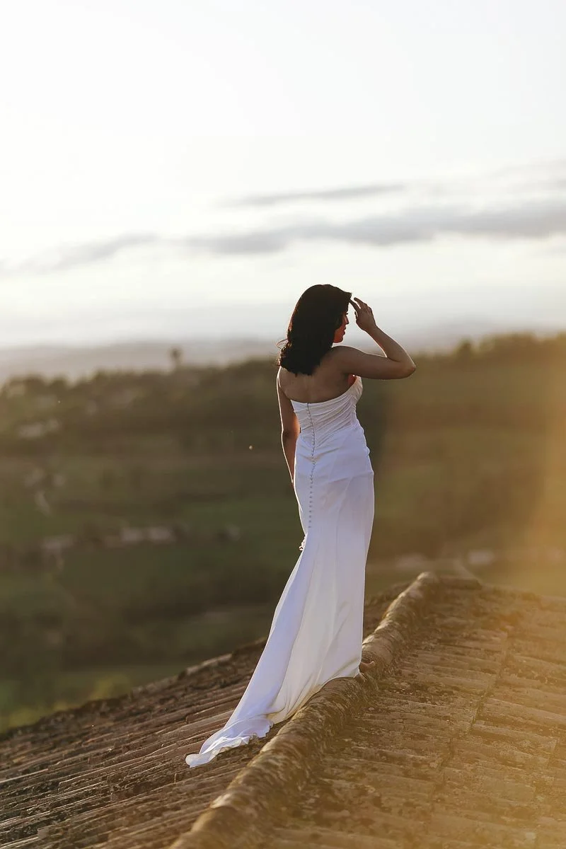 Documentary photo of the bride looking elegant and beautiful standing on the roof at Castello di Montignano wedding Umbria. Photo by Rellini art studio best wedding photographer in Umbria