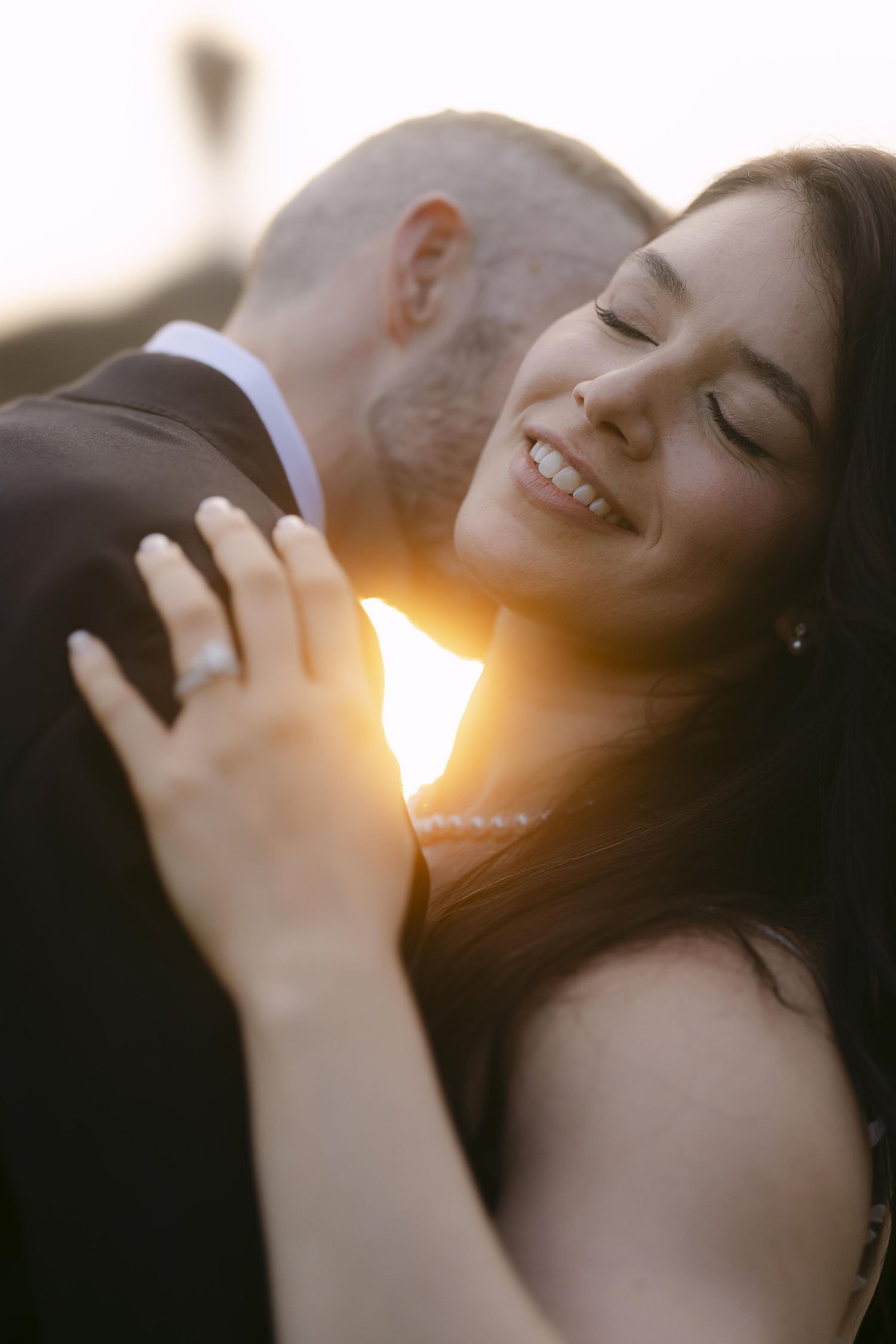 Groom kissing the neck of the bride with the sunset light