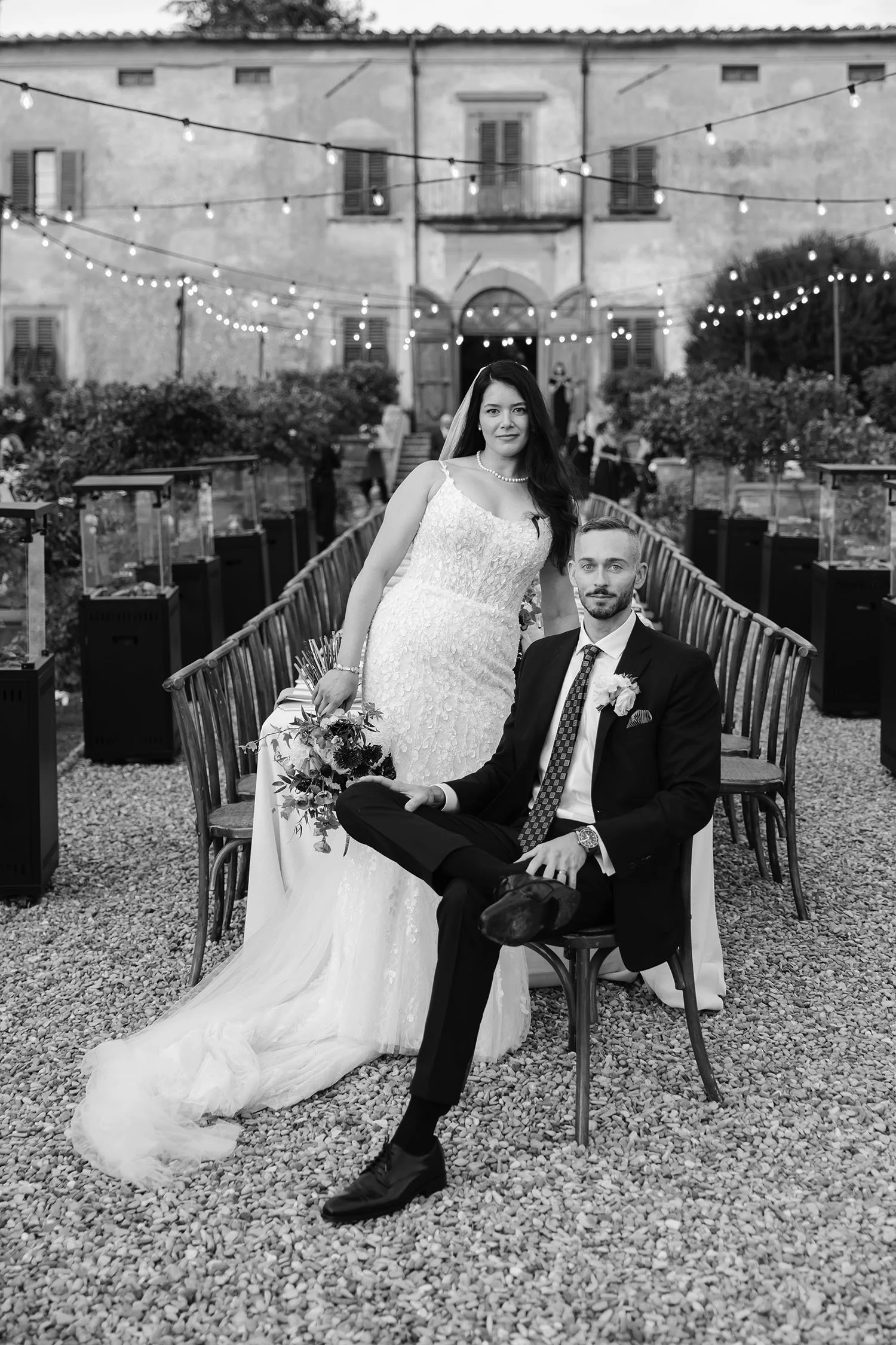 Bride and groom posing by the dinner table and looking into the camera