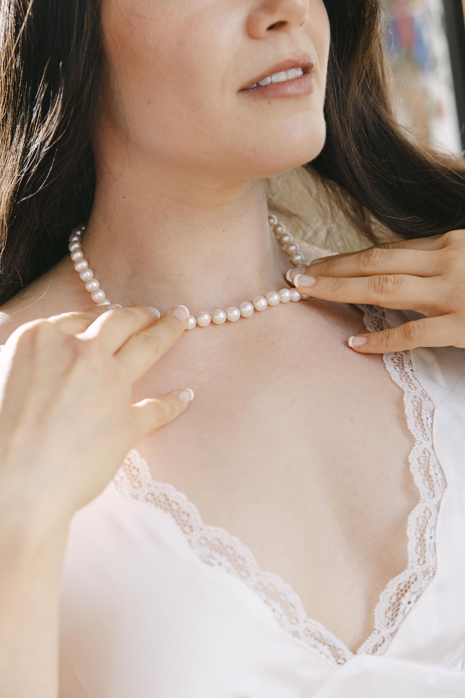 Bride fixing her necklace