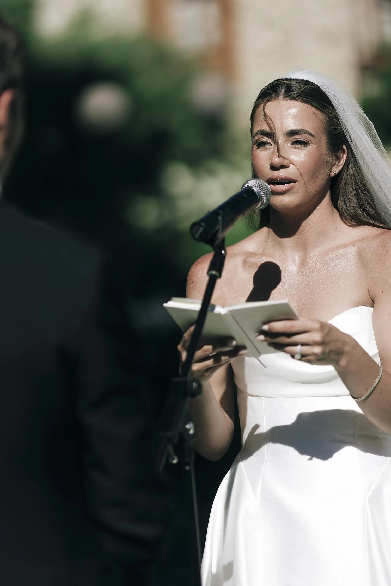 bride reading her voews with the groom holding his son and listening carefully