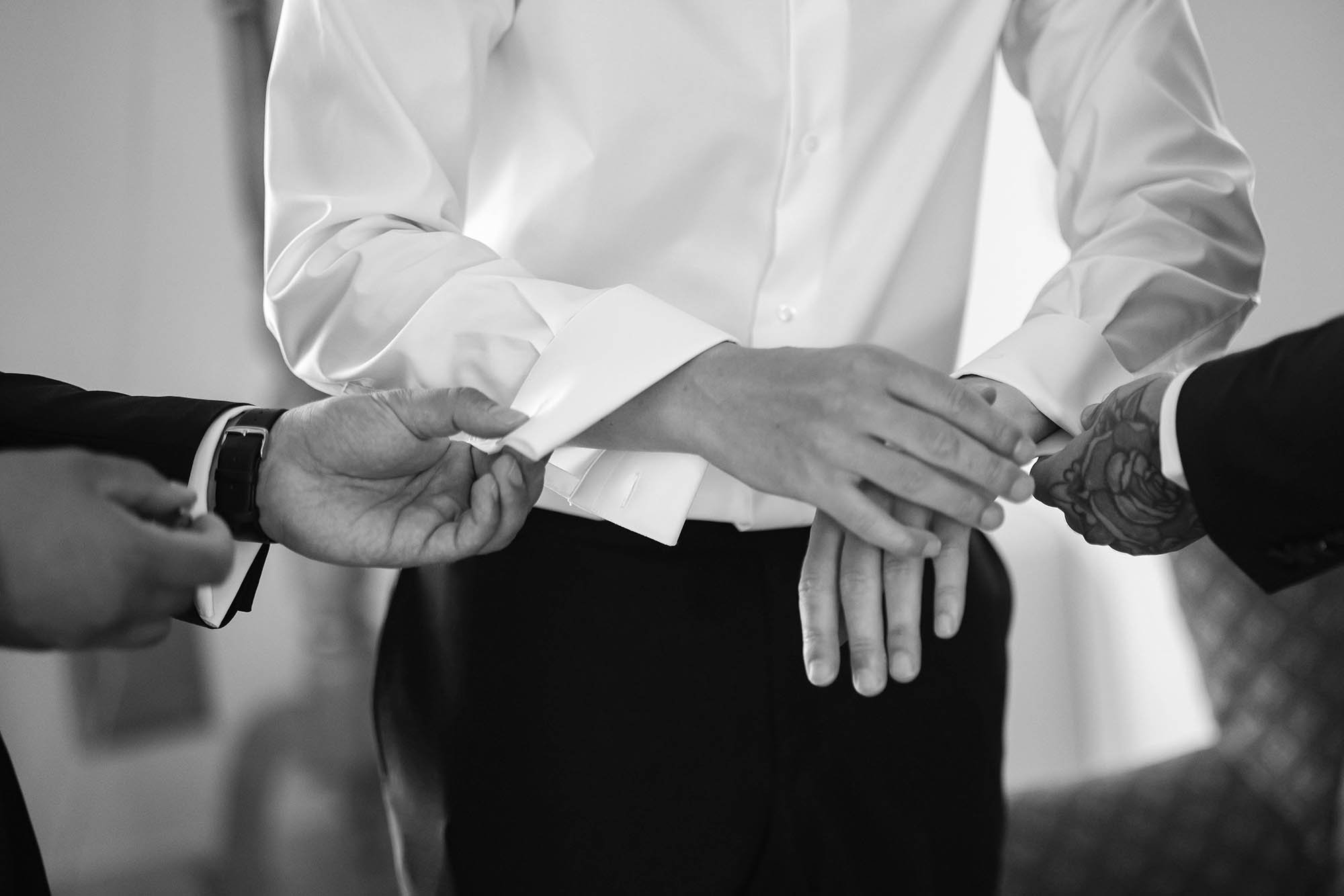 groomsmen helping the groom getting dressed