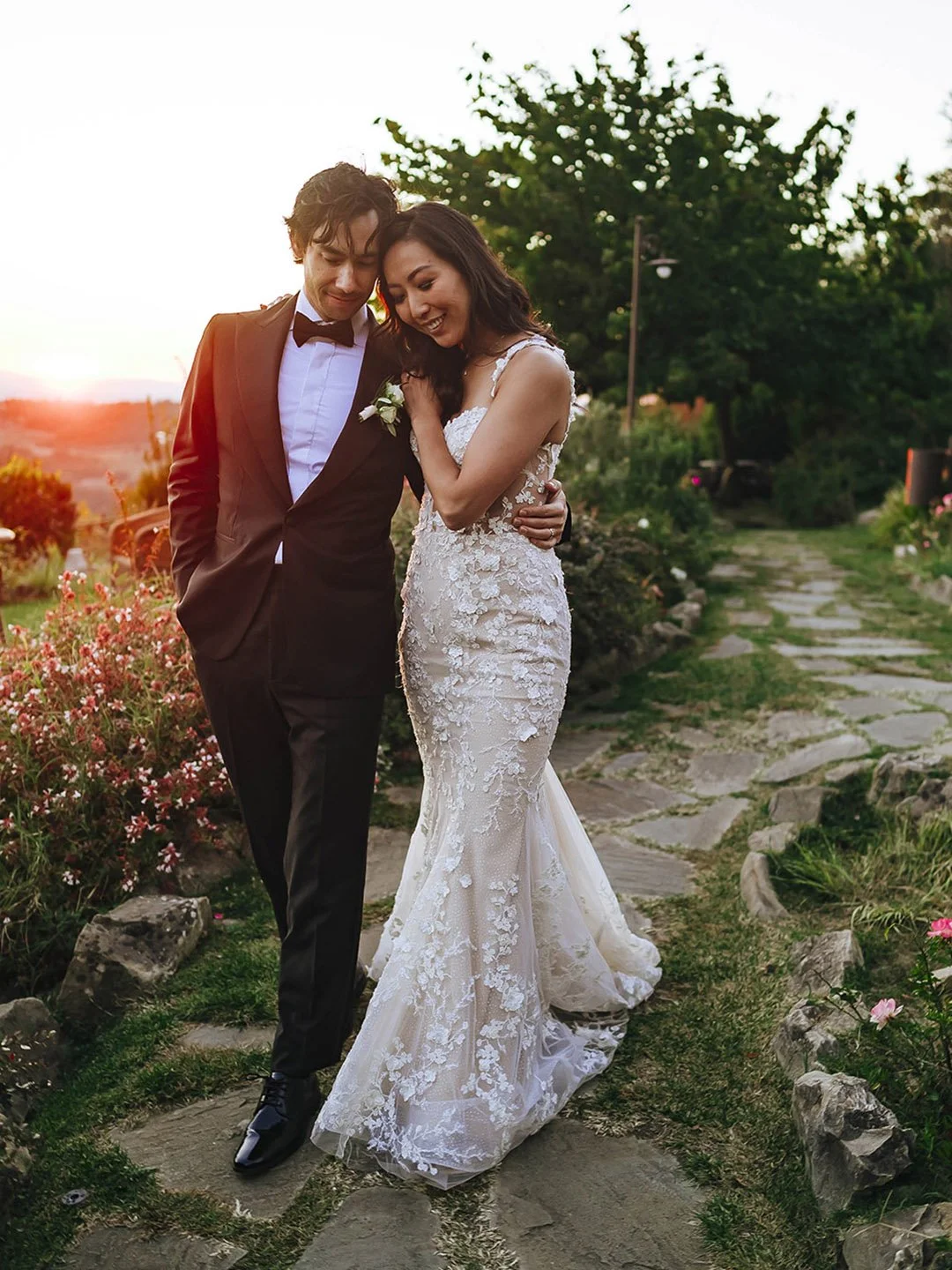 bride and groom walking together at sunset in the gardens in bloom