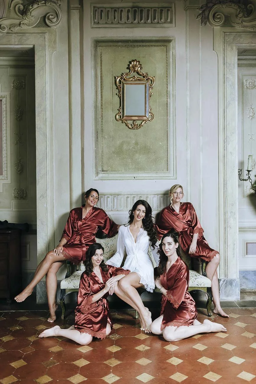 Destination wedding at Castello di Montegufoni in Florence, photo by Rellini art studio documentary wedding photographers in Tuscany. Posed group of the Bride with her bridesmaids in their pijamas during the getting ready
