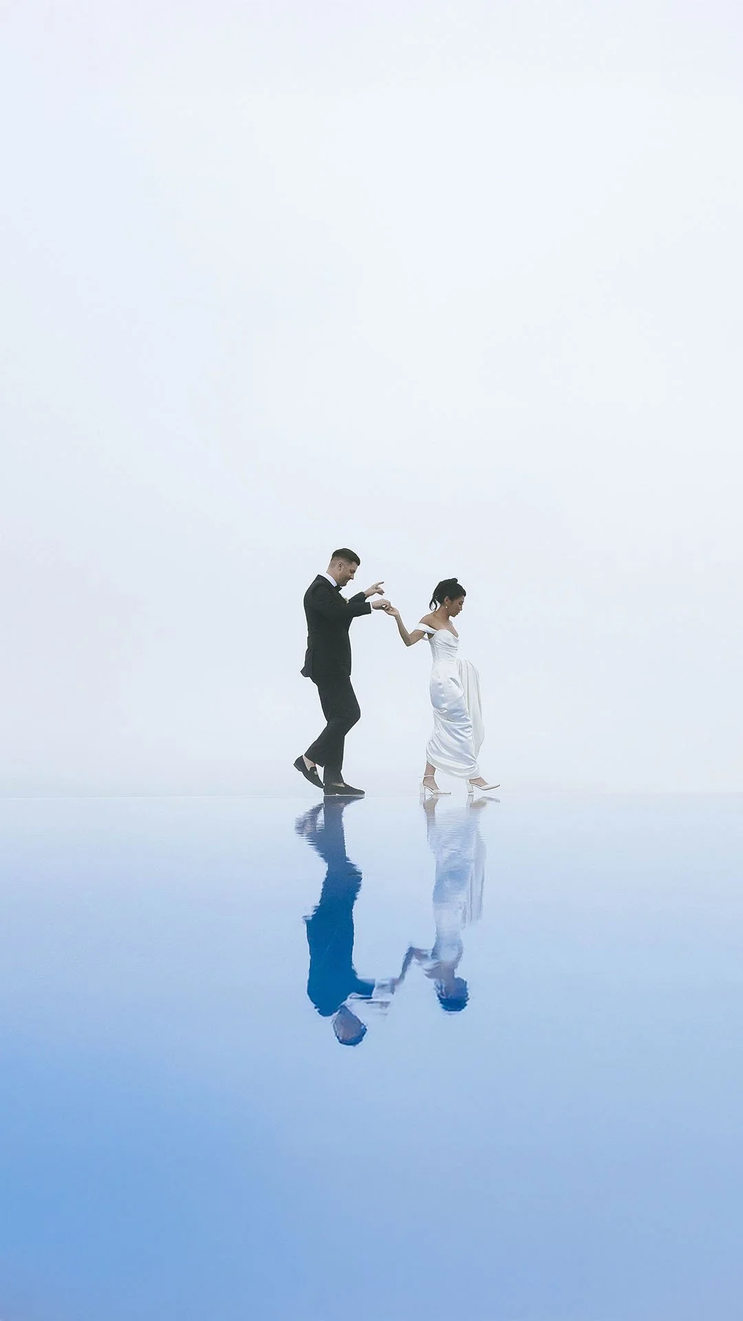 bride and groom walking on the edge of the swimming pool at Belmond Hotel Caruso in Ravello on a foggy day