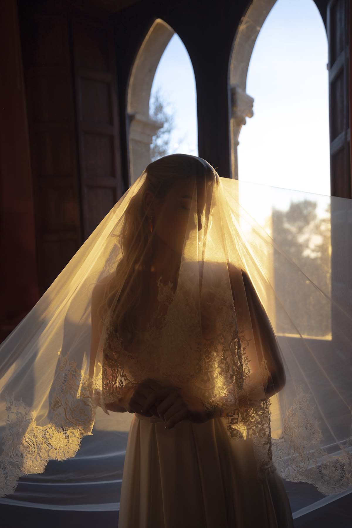 An editorial photo of the bride getting ready under the veil. Documentary and editorial style photo by Rellini art studio, best wedding photographers in Italy