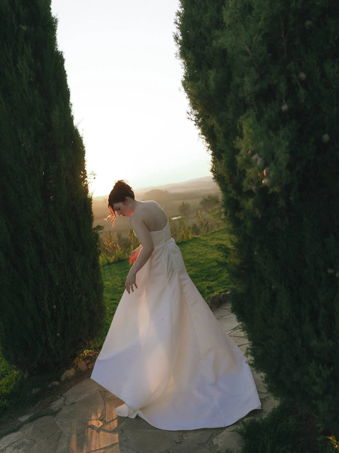 destination-wedding-tuscany-siena-borgo-laticastelli-photographer. candid moment of the bride fixing her dress