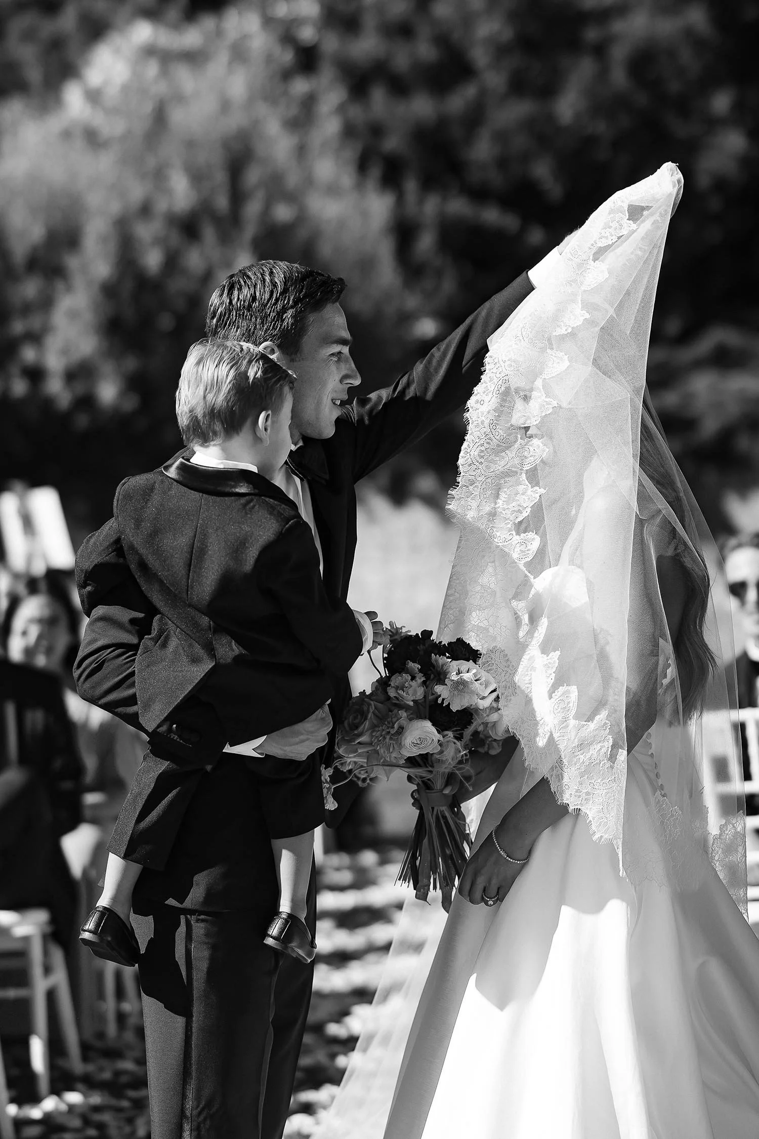 the groom helps the bride lifting her veil