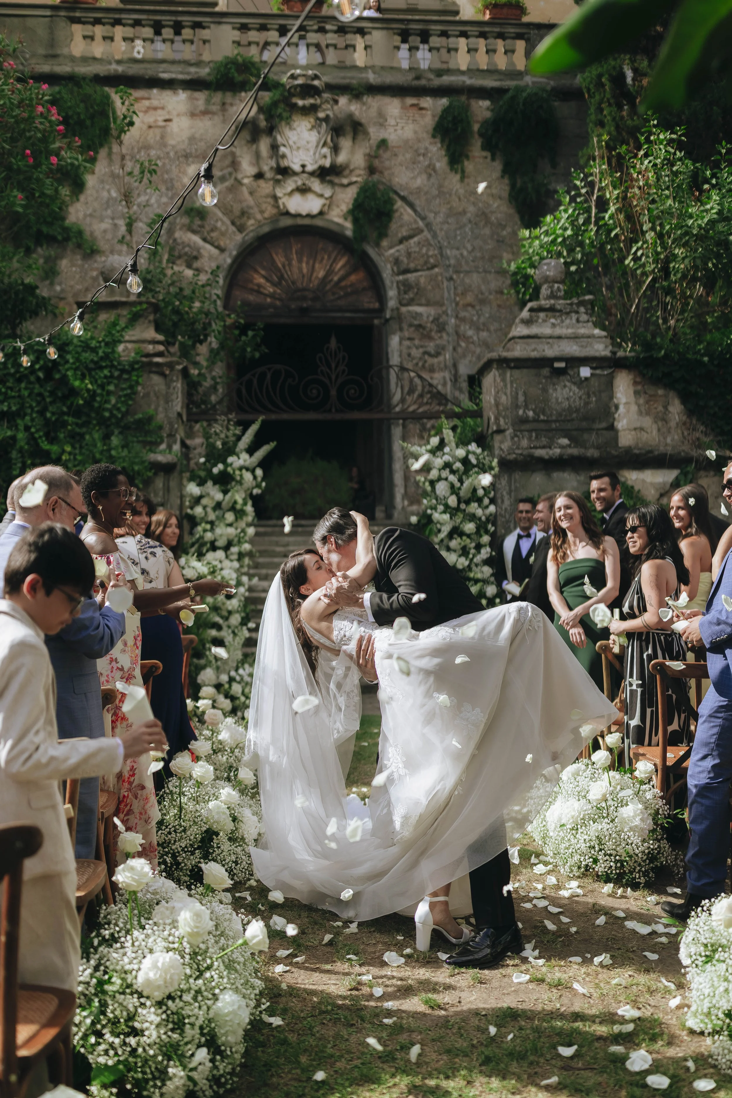 Destination wedding at Montegufoni castle near Florence in Tuscany. Bride and groom kissing down the aisle after their ceremony