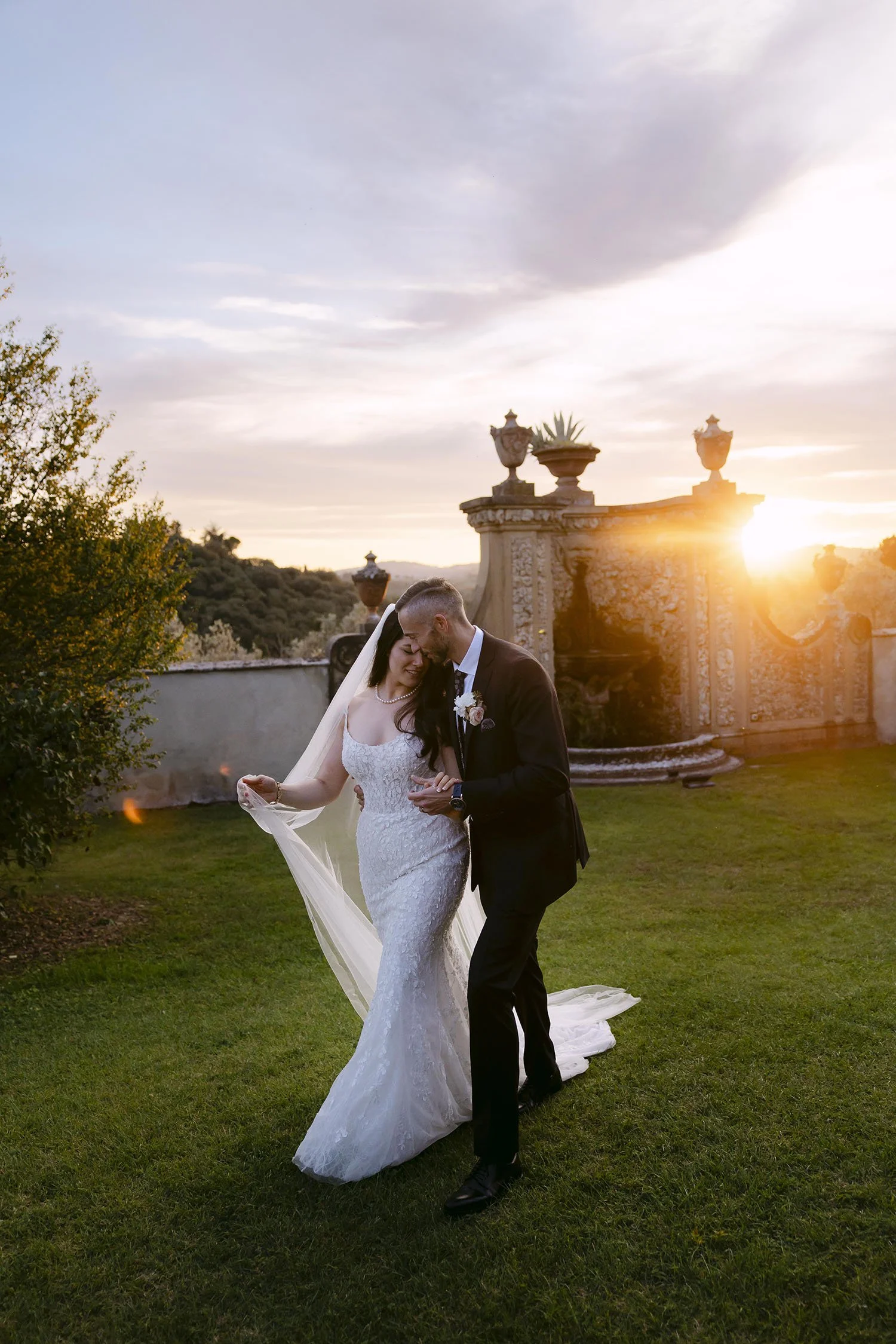 Bride and groom walking together with a warm sunset light with the iconic architecture of Villa Medicea di Lilliano
